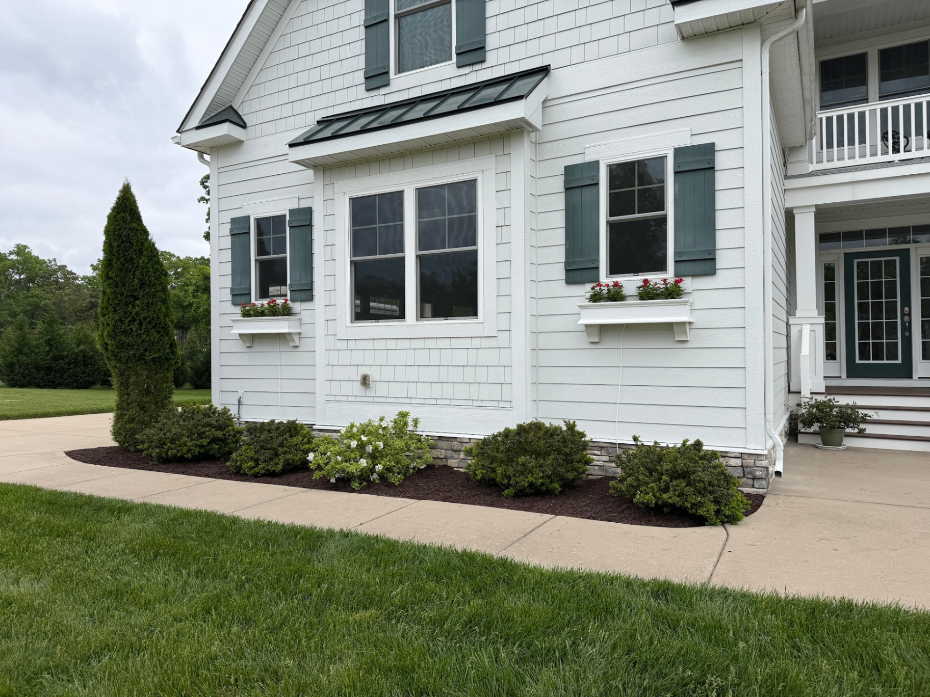 Pruned shrubs and fresh mulch along a foundation bed